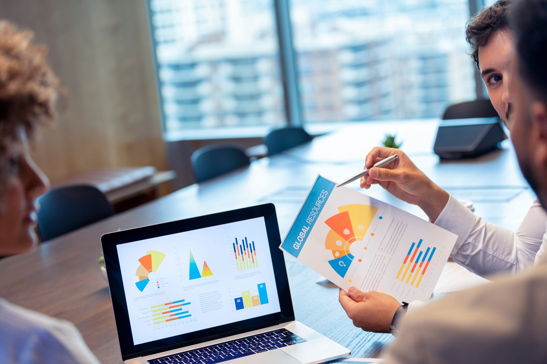 Businessman holding a document and pointing to a graph with data.